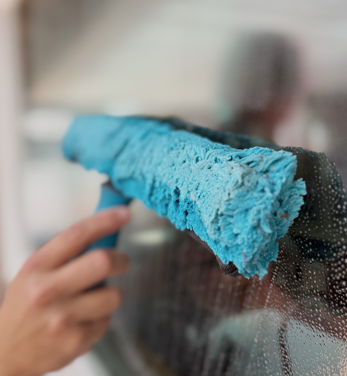 Professional window cleaning with a squeegee in San Diego