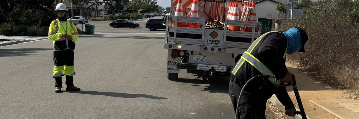 Top Tier Exterior Service crew pressure washing curb and street with traffic control for Gregg Drilling in San Diego